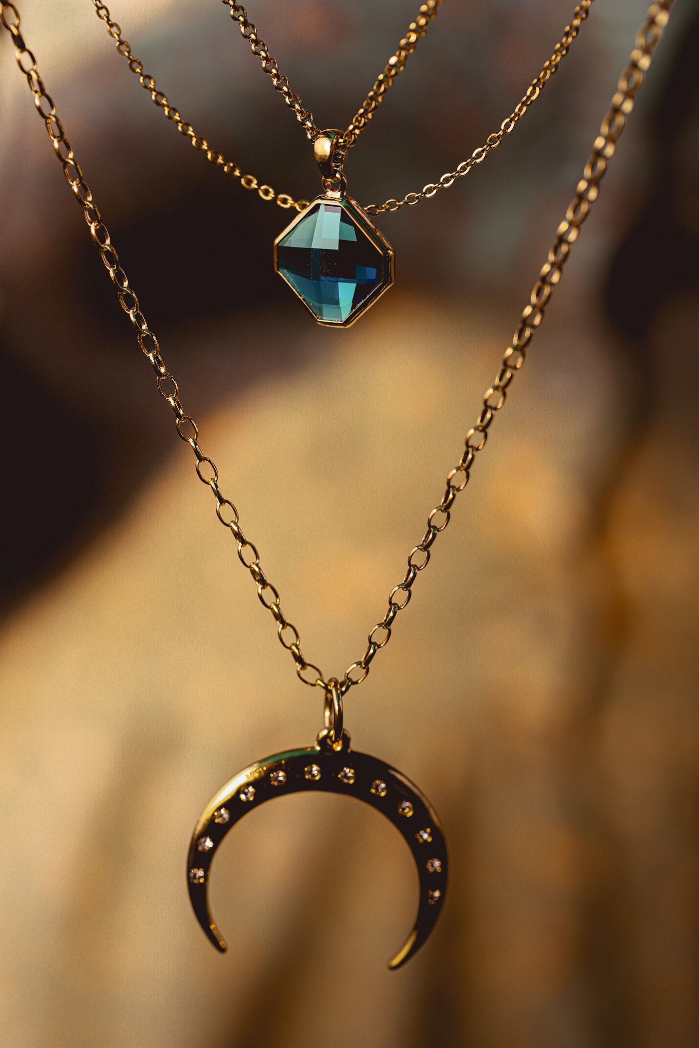 Layered gold necklaces with a crescent pendant