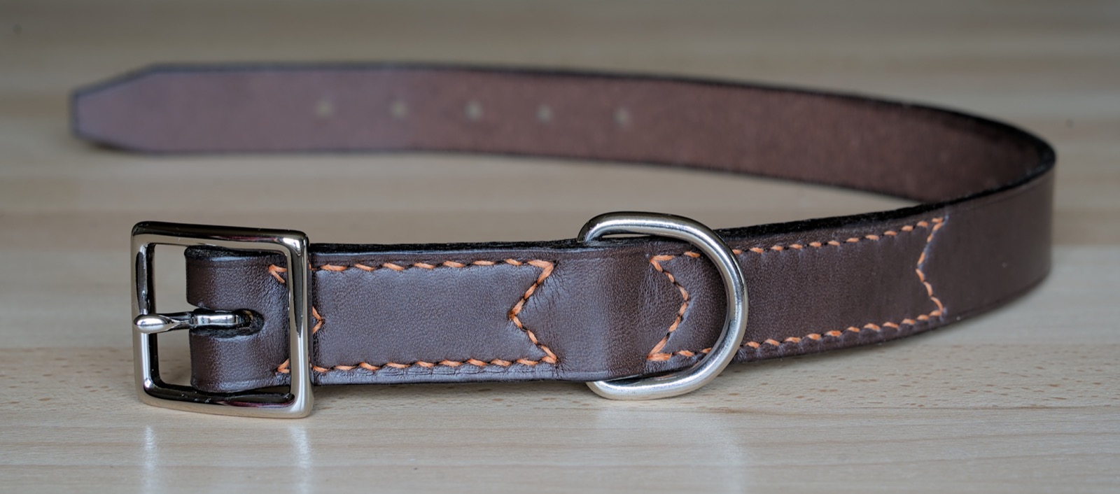A brown leather dog collar with contrast stitching
